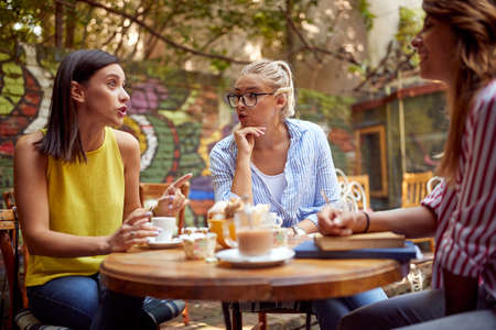 A group of female students is gossiping while having a drinkの写真素材