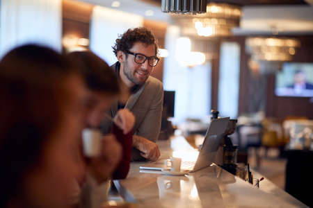 young handsome caucasian businessman working from a bar, drinking coffeeの写真素材