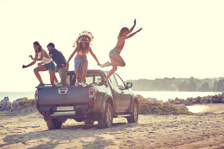 Group of adventurous friends arriving to the beach while having roadtrip