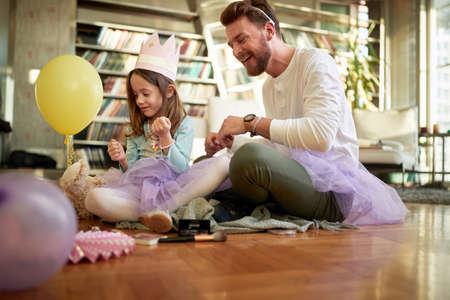 A young father and his little daughter spending a quality time together while preparing for a ballet training in a relaxed atmosphere at home. Family, together, homeの写真素材