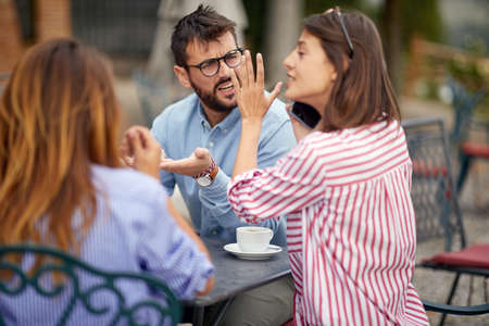 Three students drinking coffee together in the morningの写真素材