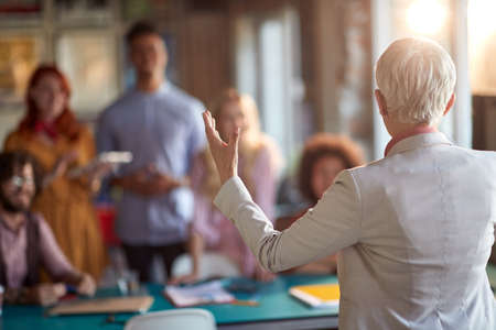 Elderly female boss in a meeting with office staff in a working atmosphere. Employees, office, workの写真素材