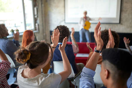 A group of young creative people are congratulating on an interesting presentation in a pleasant...