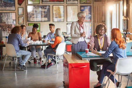 Group of young creative employees and their female boss in a working atmosphere in the office