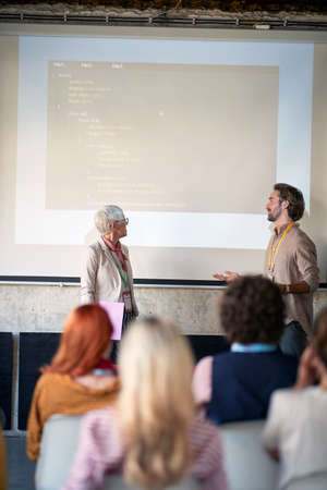 A young man is holding a presentation for his colleagues in a pleasant atmosphere in the officeの写真素材
