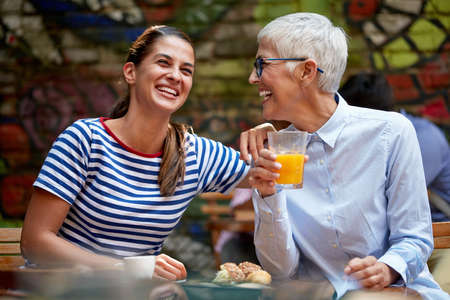 different age female friends or adult daughter and mother concept. young woman laughing loud with...