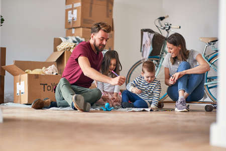 A young family in a relaxed atmosphere is enjoying the new home they have just moved in. Home, family, movingの写真素材