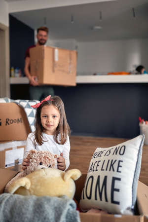 Portrait of a happy caucasian preschool girl moving in to new place