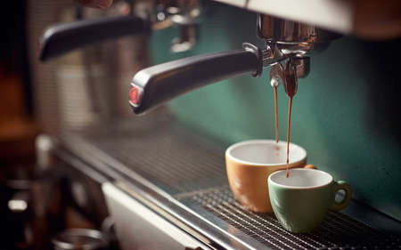 Close up of a cups filling with fresh coffee on coffee makerの写真素材