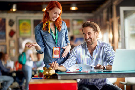 Young colleagues are enjoying while analyzing some documents at work in a friendly atmosphere in the...