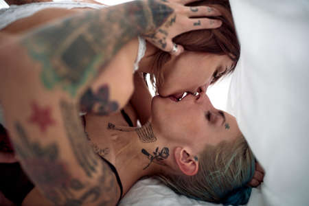 Hipster lesbian couple having a foreplay in the bedの写真素材