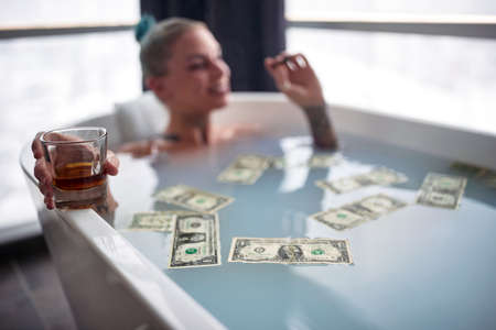 Close up of a hot punk girl taking a bath in a bath tub; Hedonistic lifestyle