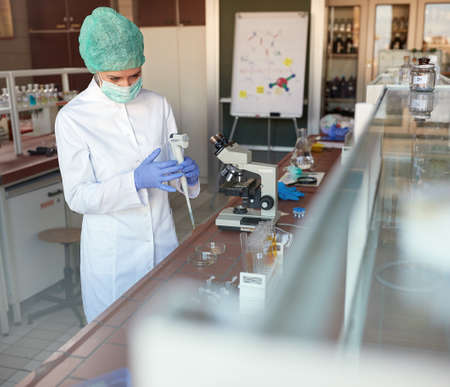 Lab worker working with automatic pipette in laboratory