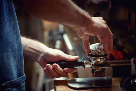A barman behind the bar is preparing an aromatic and fragrant espresso beverage. Coffee, beverage, barの写真素材