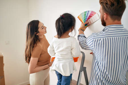 Happy multiethinc family painting walls together; Remodeling home conceptの写真素材