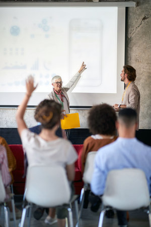 Senior colleague holding a presentation at the officeの写真素材