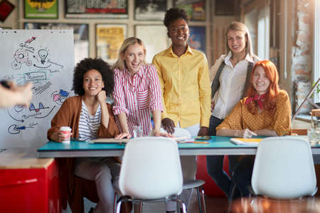 Group of beatiful female employees are posing for a photo in a pleasant atmosphere in the officeの写真素材