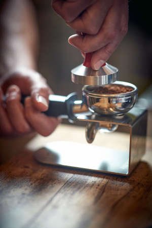 Close-up view of a barman's hands using accessories for preparing an aromatic and fragrant espresso. Coffee, beverage, barの写真素材