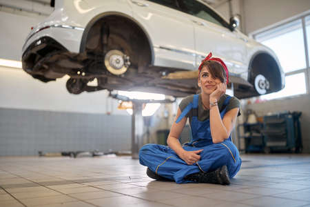 mechanic woman working on a car in an auto repair shop. Female mechanicの写真素材