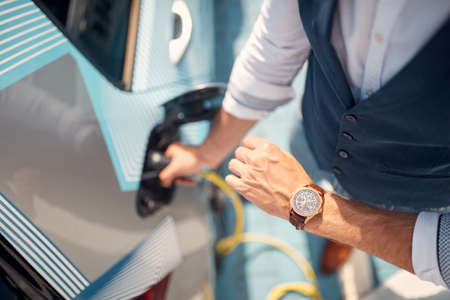 Fast charging of an electric car.Modern man charging his electric car.の写真素材