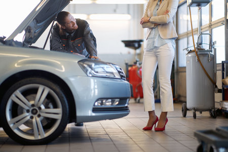 man mechanic communicates with the smiling woman clientの写真素材