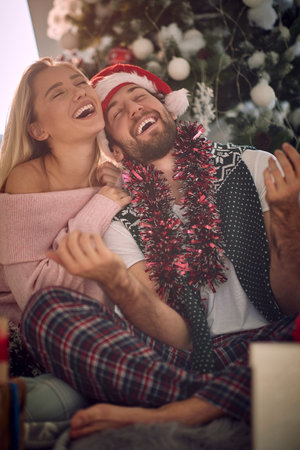 Smiling Couple celebrating Christmas at home and enjoying in holidaysの写真素材