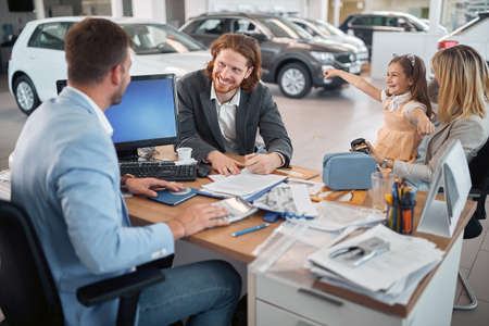 Smiling man with his family buying a new car.の写真素材