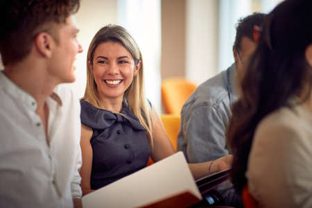 A young woman is enjoying a company of her colleagues during a business lecture in a relaxed atmosphere in the conference room. Business, people, meeting, companyの写真素材