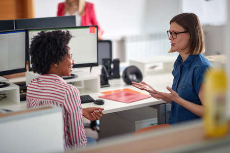 Female colleagues at job in a pleasant atmosphere in the office. Employees, job, office