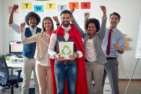 A group of cheerful employees in a pleasant atmosphere in the office is doing a great job by posing...