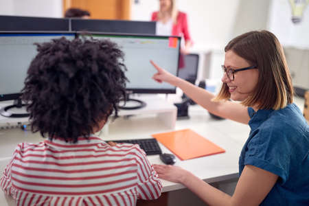 Female colleagues are discussing while working in a pleasant atmosphere in the office. Employees, job, officeの写真素材
