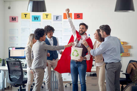 A group of employees in a cheerful atmosphere in the office is having fun while supporting cleaner...