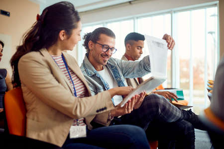Young participants at a business lecture in a pleasant atmosphere in the conference room are analyzing writings together. Business, people, companyの写真素材