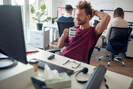 Overworked caucasian male trying to focus in the officeの写真素材