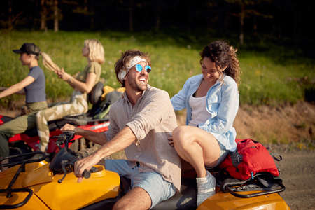 Close-up of a group of friends enjoying a quad ride on a beautiful sunny day in the nature. Riding, nature, friendship, togetherの写真素材