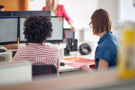 Female colleagues are focused on a work in a pleasant atmosphere in the office. Employees, job, officeの写真素材