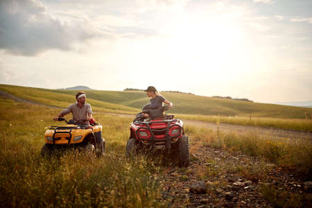 Young man and girl  driving off-road and enjoying on extreme ridingの写真素材