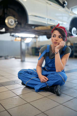 Caucasian girl mechanic working alone in the workshop