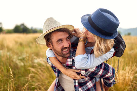 Young couple in field. Smiling Caucasian couple looking at each other and smiling. Girl...