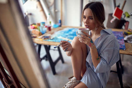 Young seductive female artist working in the studioの写真素材