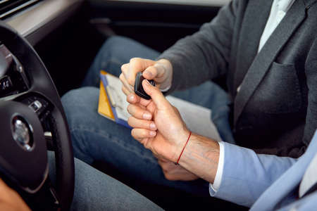 Salesman giving key of a new car to buyer in car, conceptの写真素材