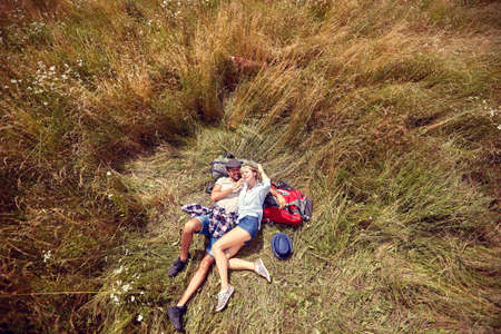 Happy Couple lying on grass enjoying peaceful sunny dayの写真素材