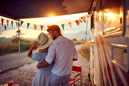 A young couple in love enjoying romantic moments at the campsite at a beautiful sunset in the...