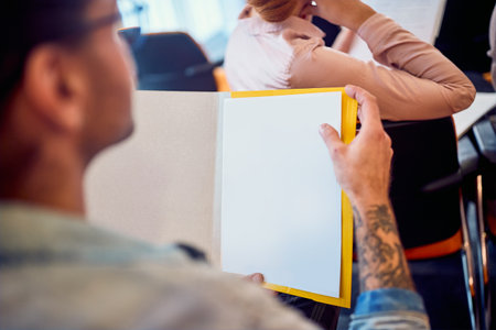 A young participant follows a draft during a business meeting in a working atmosphere in the...