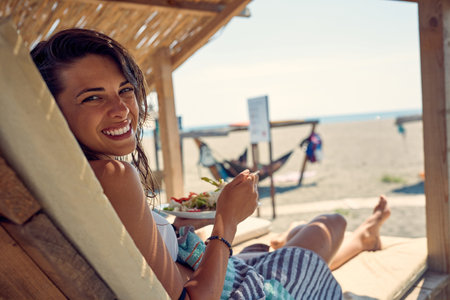 Smiling girl enjoying at sun.  Young beautiful woman lying down on sun bed sofaの写真素材