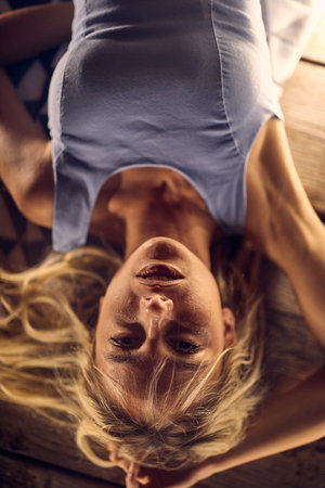 Bird's eye view of a young handsome girl posing for a photo while lying on the floor of the bar at night out on a beautiful summer night. Night, love, bar, riverの写真素材
