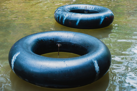 Old inner tubes floating on a river, selective focusの写真素材