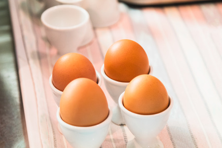 egg cups with natural brown eggsの写真素材