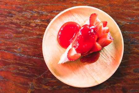 homemade cheesecake with strawberries on wooden dishの写真素材