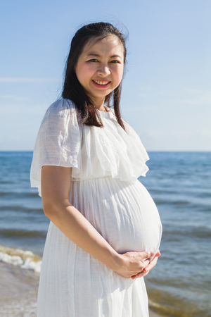 Asian pregnant women standing near the seaの写真素材